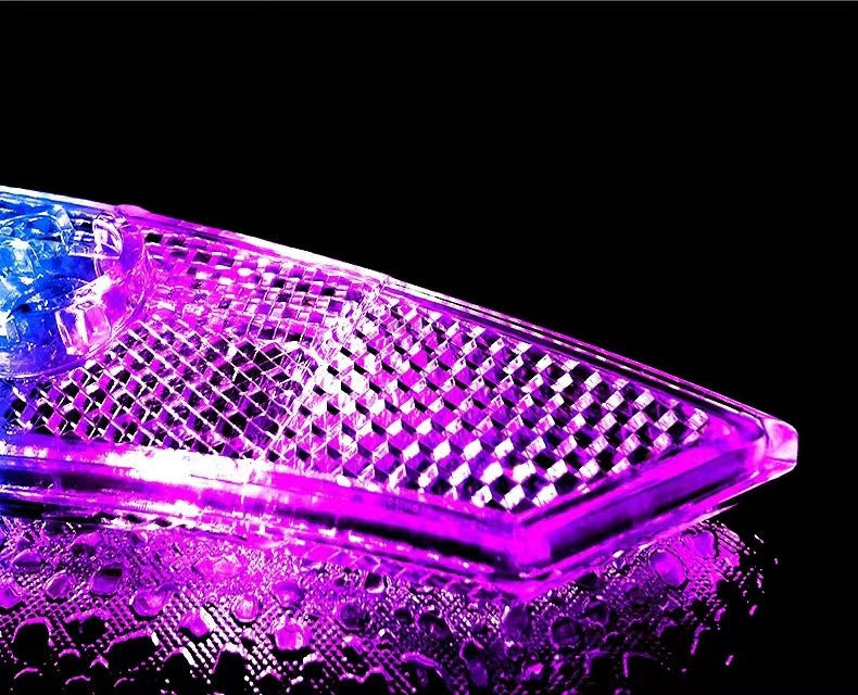 Close view of the illuminated pink-and-blue spoke light lens