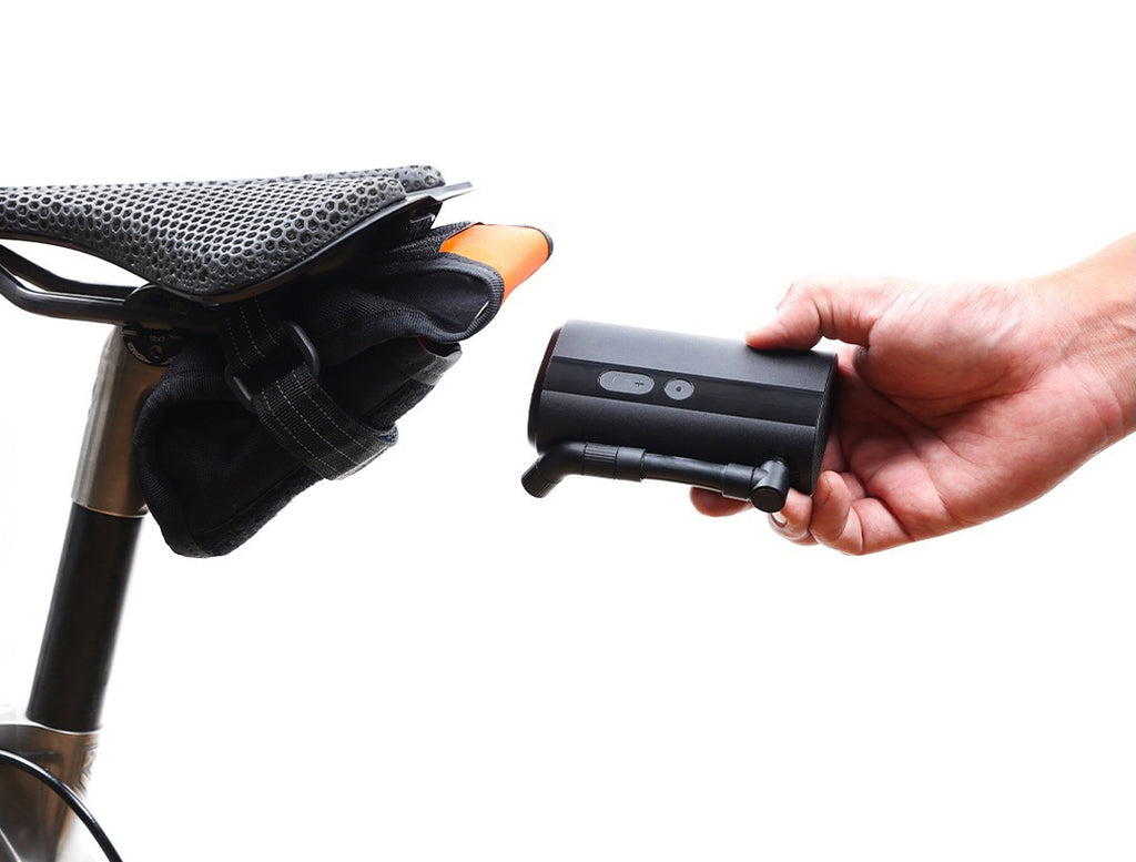 Portable electric pump held beside a bicycle saddle for use