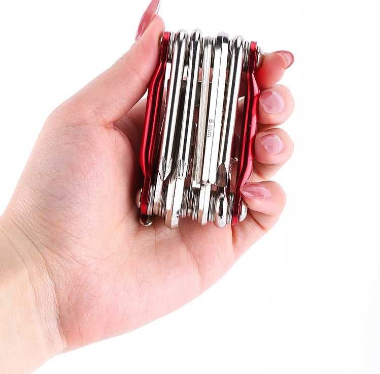 Compact bicycle multi-tool held in one hand for scale