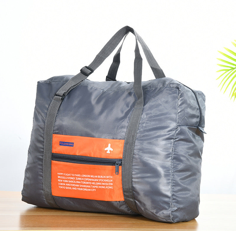 Orange foldable duffel bag displayed in a travel setting
