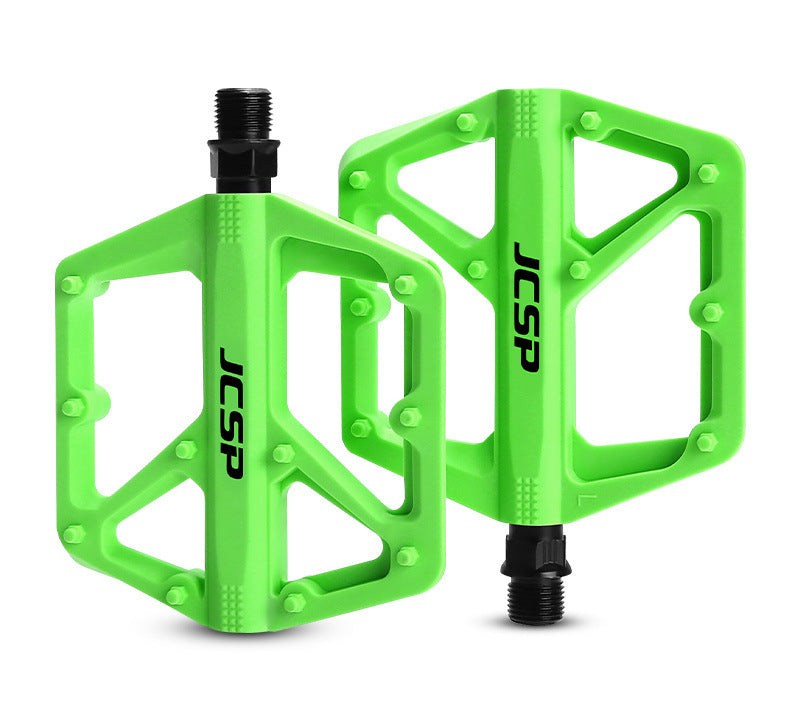 Green nylon platform bicycle pedal pair on white