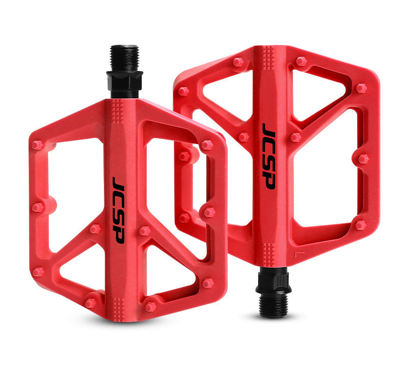 Red nylon platform bicycle pedal pair on white
